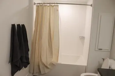 a bathroom with a shower with a shower curtain at Pacific Paradise 10 Min from Disneyland With Pool & GYM in Santa Ana