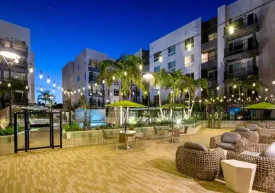 a courtyard in a building with chairs and umbrellas at Premium Stay 10 Min From Disneyland With Pool & GYM in Santa Ana