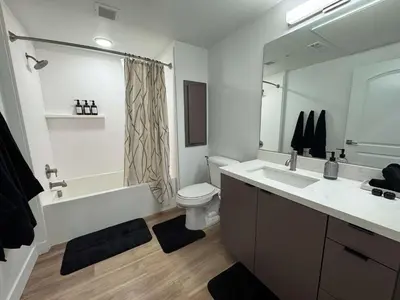 a bathroom with a tub and a toilet and a sink at Stunning Haven with Pool Gym Parking Close to Disneyland in Santa Ana