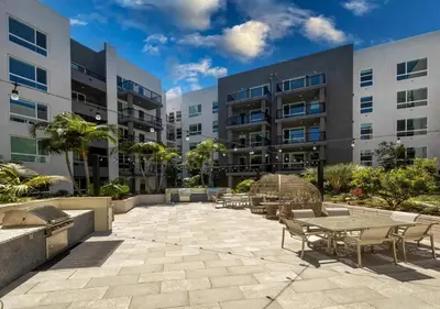 a patio with tables and chairs in front of a building at Stunning Haven with Pool Gym Parking Close to Disneyland in Santa Ana
