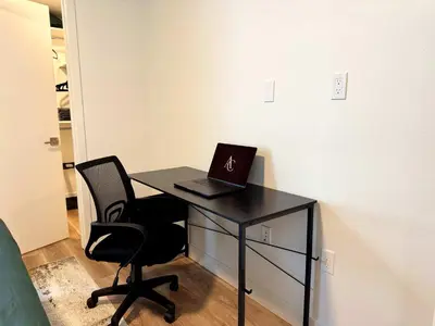 a desk with a laptop computer on top of it at Elegant Escape 10 Min from Disneyland With Pool & GYM in Santa Ana
