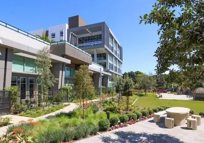 a building with a garden in front of it at Modern Retreat 10 Min from Disneyland With Pool & Gym in Santa Ana