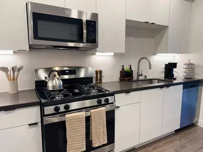 a kitchen with a stove and a microwave at Modern Retreat 10 Min from Disneyland With Pool & Gym in Santa Ana