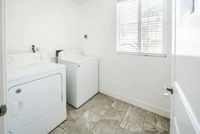 a white laundry room with a washer and dryer at Spacious 5BR 3BA Home with Free Parking and WiFi 10 Minutes to Downtown LA Perfect for Large Groups in Los Angeles