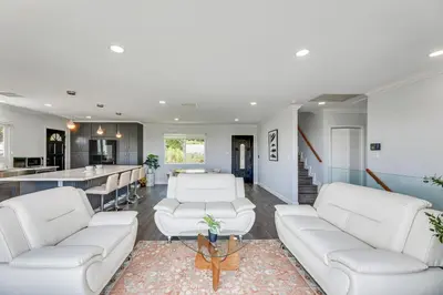 a living room with white couches and a kitchen at Enchanting 4-bedroom house with panoramic view in Pasadena in Los Angeles