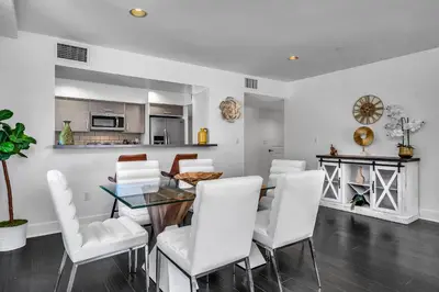a dining room with a glass table and white chairs at Amazing & Spacious in Heart of Santa Monica- Easy Access to ALL Tourist attractions in Los Angeles