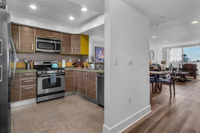 a kitchen with wooden cabinets and a dining room at Amazing Spacious Unit in Heart of LA- Melrose district in Los Angeles