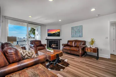 a living room with leather furniture and a fireplace at Amazing Spacious Unit in Heart of LA- Melrose district in Los Angeles