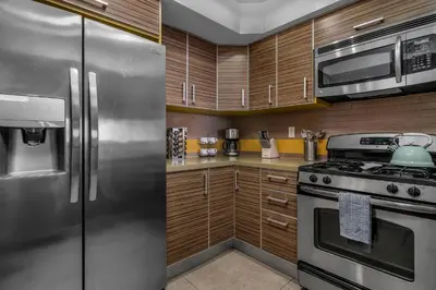 a kitchen with stainless steel appliances and wooden cabinets at Amazing Spacious Unit in Heart of LA- Melrose district in Los Angeles