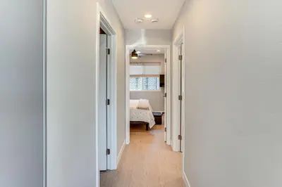 a hallway with white walls and a bed in a bedroom at Newly Updated! Commuter-Friendly Anaheim Home in Anaheim