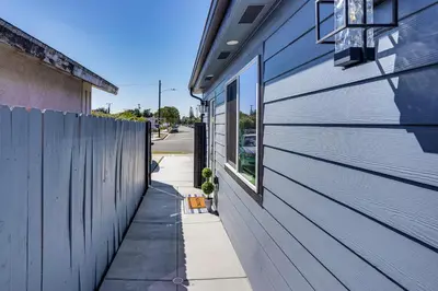 a sidewalk next to a building with a fence at Newly Updated! Commuter-Friendly Anaheim Home in Anaheim