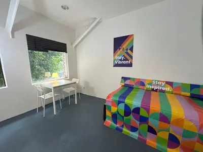 a bedroom with a colorful bed and a table at The Art Nook Private Rooms on Hollywood Blvd in Los Angeles