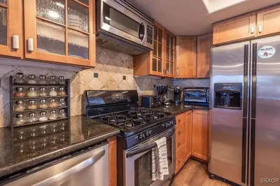 a kitchen with stainless steel appliances and wooden cabinets at Lake Forest Shores at Big Bear Lake in Big Bear Lake