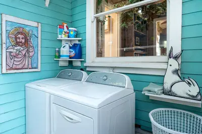a washing machine in a blue house with a window at Urban Farmhouse in Venice Walk to Abbot Kinney w Patio and Parking in Los Angeles