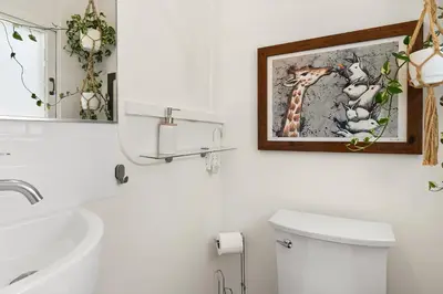a bathroom with a toilet and a picture of a giraffe at Urban Farmhouse in Venice Walk to Abbot Kinney w Patio and Parking in Los Angeles