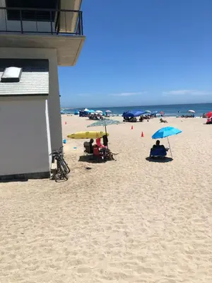 a beach with people sitting under umbrellas on the sand at Luxury, Beach House, and quiet neighborhood in Oxnard
