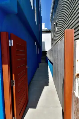 a hallway of a blue building with a red door at Luxury, Beach House, and quiet neighborhood in Oxnard