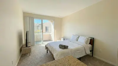 a bedroom with a bed and a television and a window at Marina del Rey Family 1BA & 2BA - Pool, Spa and Gym Access in Los Angeles