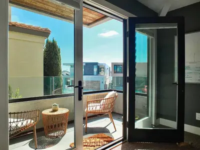 an open door to a balcony with chairs and a table at Naples Luxury Retreat - 3 BDR Stay for 6 w Rooftop Patio in Long Beach