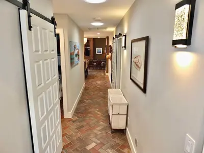 a hallway with a door and a chair in a room at Naples Luxury Retreat - 2 BDR Walk to Beach Dining & Shops in Long Beach