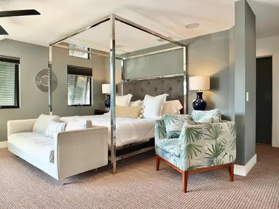 a bedroom with a canopy bed and a chair at Naples Luxury Retreat - 2 BDR Walk to Beach Dining & Shops in Long Beach