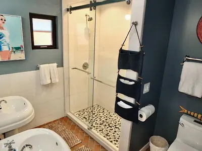 a bathroom with a shower and a toilet and a sink at Naples Luxury Retreat - 2 BDR Walk to Beach Dining & Shops in Long Beach