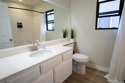 a white bathroom with a sink and a toilet at CA2 House SoCal Oasis Newly Renovated Game Room in La Palma