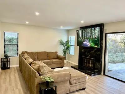 a living room with a couch and a flat screen tv at CA2 House SoCal Oasis Newly Renovated Game Room in La Palma