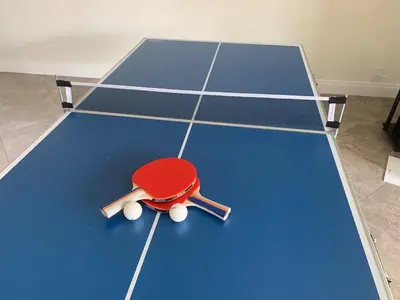 a ping pong table with a red ping pong racket at CA3 House Spacious SoCal Home for Groups in La Palma