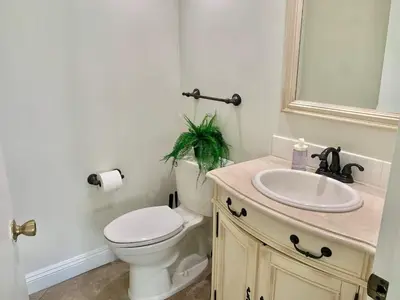 a bathroom with a toilet and a sink and a mirror at CA3 House Spacious SoCal Home for Groups in La Palma