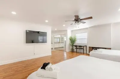 a living room with a bed and a flat screen tv at CA3 House Spacious SoCal Home for Groups in La Palma