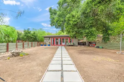 a house with a red door and a dirt yard at Cornell Canyon Getaway in Agoura Hills