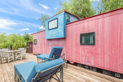 a red train car with two chairs and a table at Cornell Canyon Getaway in Agoura Hills