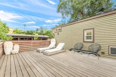 a wooden deck with two chairs and a house at Cornell Canyon Getaway in Agoura Hills
