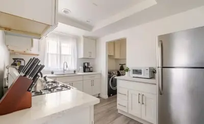 a kitchen with white cabinets and a stainless steel refrigerator at CA5 House Cozy 3BR in Azusa in Azusa