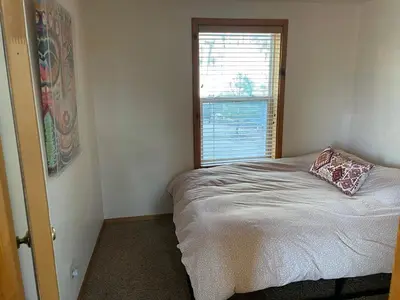 a small bedroom with a bed and a window at Lakefront Oasis in Fawnskin