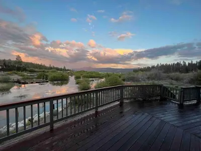 a view of a river from a wooden deck at Lakefront Oasis in Fawnskin