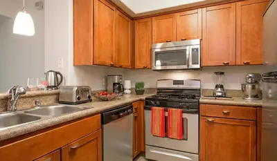 a kitchen with stainless steel appliances and wooden cabinets at Marina Del Rey View 1BA & 2BA in MDR - Pool, Jacuzzi, Gym in Los Angeles