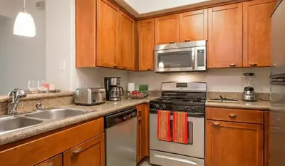 a kitchen with stainless steel appliances and wooden cabinets at Marina Del Rey View 1BA & 2BA in MDR - Pool, Jacuzzi, Gym in Los Angeles