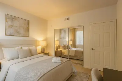 a bedroom with a white bed and a mirror at Marina del Rey 2BR with Pool, Hot Tub, and Gym in Los Angeles