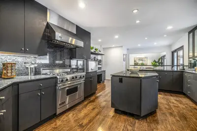 a large kitchen with stainless steel appliances and wood floors at Shirley Lane in Los Angeles