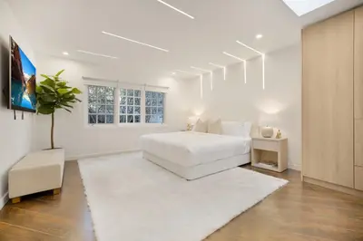 a white bedroom with a white bed and a white rug at Shirley Lane in Los Angeles