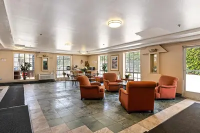 a large lobby with chairs and tables and windows at Paradise Lodge - Canoga Park, Los Angeles in Winnetka