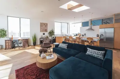 a living room with a blue couch and a kitchen at Industrial&Stylish 3 bedroom 3 bathrooms Home With Views and Hot tub in Los Angeles
