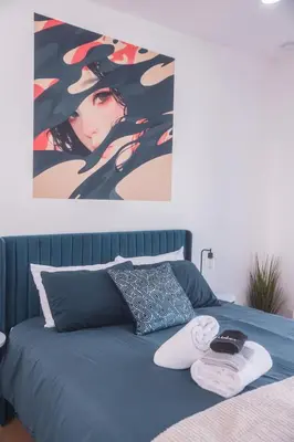 a bedroom with a bed with a painting on the wall at Industrial&Stylish 3 bedroom 3 bathrooms Home With Views and Hot tub in Los Angeles