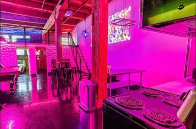 a pink room with a bar with tables and chairs at Arts District DTLA-Artist Loft With Free Parking and Pooltable in Los Angeles