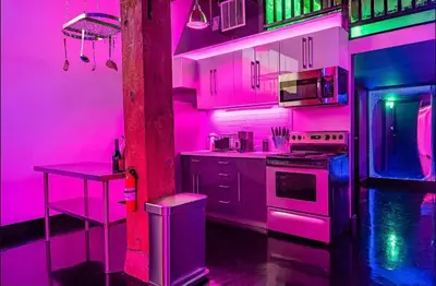 a pink kitchen with a table and a stove at Arts District DTLA-Artist Loft With Free Parking and Pooltable in Los Angeles