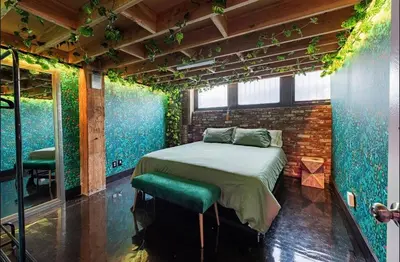 a bedroom with a bed with plants on the walls at Arts District DTLA-Artist Loft With Free Parking and Pooltable in Los Angeles