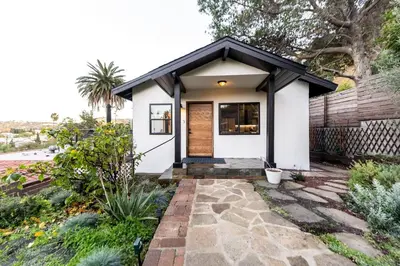 a small white house with a black roof at Hidden Oasis 3 bedroom 2 bathroom Home With large backyard and Views Near DTLA in Los Angeles