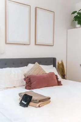 a white bed with two pictures on the wall at Welcoming Claremont Studio With Private Yard and Pool Spa in Claremont